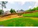 Lush backyard featuring a gently sloping lawn, privacy fence, and mature trees offering privacy at 4311 Hampton Mill Pkwy, Douglasville, GA 30135