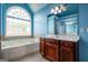 Stylish bathroom featuring a soaking tub, vanity with dark cabinets, and a large window at 4311 Hampton Mill Pkwy, Douglasville, GA 30135