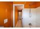 A bright orange bathroom features white shower and tile and a door open to the hallway at 4311 Hampton Mill Pkwy, Douglasville, GA 30135