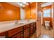 Bright orange bathroom featuring a double sink vanity, tiled floor, and white trim at 4311 Hampton Mill Pkwy, Douglasville, GA 30135