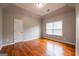 Neutral bedroom with hardwood floors, window, and light fixture creating a comfortable atmosphere at 4311 Hampton Mill Pkwy, Douglasville, GA 30135