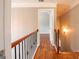 Hardwood hallway features wood and iron banister, doorway, and wall sconce at 4311 Hampton Mill Pkwy, Douglasville, GA 30135