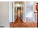 Hallway with hardwood floors, white trim, and lighting, leading to other rooms at 4311 Hampton Mill Pkwy, Douglasville, GA 30135