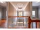 Hallway with hardwood floors, banister and iron spindles leads to bedrooms at 4311 Hampton Mill Pkwy, Douglasville, GA 30135