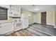 Bright kitchen with white appliances and a glimpse into a spacious room with brick accents at 758 King Rd, Jonesboro, GA 30236