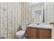 Small bathroom featuring patterned wallpaper, toilet, sink with vanity, and a mirror at 453 Camp Hill Ln, Jonesboro, GA 30238