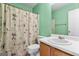 Bathroom with light green walls, a single sink vanity, toilet, and shower with a decorative curtain at 453 Camp Hill Ln, Jonesboro, GA 30238