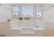Bathroom features a white, built-in bathtub surrounded by tile with a floral pattern at 453 Camp Hill Ln, Jonesboro, GA 30238