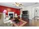 Inviting living room with hardwood floors, a fireplace, and red accent wall at 453 Camp Hill Ln, Jonesboro, GA 30238