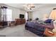 Spacious main bedroom featuring plush carpet, a ceiling fan, and a TV on a wooden dresser at 453 Camp Hill Ln, Jonesboro, GA 30238