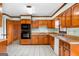 Traditional kitchen features wood cabinets and white appliances with an adjacent dining area at 210 Heritage Cir, Mcdonough, GA 30253