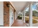 Charming brick porch with tiled floor, decorative columns, and a view of the landscaped yard at 210 Heritage Cir, Mcdonough, GA 30253