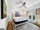 Bright bedroom with natural light, hardwood floors, a comfortable bed, and clean minimalist decor at 9135 Selborne Ln, Chattahoochee Hills, GA 30268