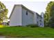 Spacious backyard featuring lush green lawn, mature trees, raised garden bed and exterior of the home at 1067 Misty Meadows Pt, Hampton, GA 30228