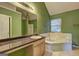 En-suite bathroom features a garden tub, a spacious vanity, a large mirror and coordinated tile at 1067 Misty Meadows Pt, Hampton, GA 30228