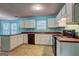 Well-lit kitchen features white cabinets, dark countertops, tile flooring, and modern appliances for easy living at 1067 Misty Meadows Pt, Hampton, GA 30228