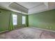 Large bedroom with tray ceiling, plush carpet, and two windows offering plenty of natural light at 1067 Misty Meadows Pt, Hampton, GA 30228