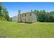 Back exterior view features the home, chimney, and spacious yard at 470 Louise Way, Locust Grove, GA 30248