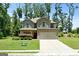 Beautiful two-story home with gray siding and a brick-accented garage, surrounded by a lush green lawn and mature trees at 470 Louise Way, Locust Grove, GA 30248