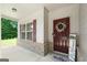 Welcoming front porch with brick accents, a maroon door with a wreath, and charming decor at 470 Louise Way, Locust Grove, GA 30248