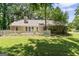 Backyard view featuring a large chimney and white picket fence at 380 Peach Drive, Mcdonough, GA 30253