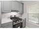 Close-up of a modern gas range and gray cabinetry in the kitchen at 380 Peach Drive, Mcdonough, GA 30253