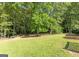 Spacious backyard with mature trees and lush lawn at 115 Brookwood Ln, Fayetteville, GA 30215