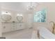 Bright bathroom featuring a modern tub, double vanity, decorative lights, and a large window with lush views at 115 Brookwood Ln, Fayetteville, GA 30215