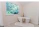 Bathroom showcasing a luxurious stand-alone tub with gold fixtures and a large window with nature views at 115 Brookwood Ln, Fayetteville, GA 30215