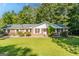 Charming brick home with a well-manicured lawn and mature trees offering an inviting curb appeal at 115 Brookwood Ln, Fayetteville, GA 30215