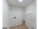 A tidy laundry room with vinyl flooring, basic hookups, and white wire shelving for efficient storage at 115 Brookwood Ln, Fayetteville, GA 30215