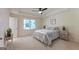 Bright main bedroom with a ceiling fan, tray ceiling, and a large window offering pleasant outdoor views at 115 Brookwood Ln, Fayetteville, GA 30215