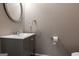 Charming powder room features a gray vanity with a sink, framed round mirror, and neutral wall color at 1360 Mount Mckinley Dr, Grayson, GA 30017