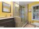 Well-lit bathroom with a large glass shower, gray vanity, stone countertops and yellow walls at 1360 Mount Mckinley Dr, Grayson, GA 30017