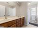Bathroom featuring double sinks with wooden cabinets, large mirror, and a view into the toilet and shower at 1360 Mount Mckinley Dr, Grayson, GA 30017