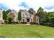 Stately brick home featuring manicured lawn, mature trees and decorative stone accents at 1360 Mount Mckinley Dr, Grayson, GA 30017
