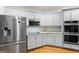Modern kitchen with stainless steel appliances, white cabinets, and granite countertops at 1360 Mount Mckinley Dr, Grayson, GA 30017