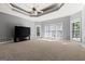 Large living room with a tray ceiling, ceiling fan, and a door to the backyard at 1360 Mount Mckinley Dr, Grayson, GA 30017