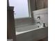 Bathroom soaking tub with neutral tile surround, fixtures, and frosted privacy window at 160 Elysian Dr, Fayetteville, GA 30214