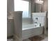Well-lit bathroom featuring a soaking tub with decorative tile surround and a frosted window at 160 Elysian Dr, Fayetteville, GA 30214