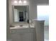 Bathroom vanity with white cabinets, tile backsplash, decorative mirror, and frosted window at 160 Elysian Dr, Fayetteville, GA 30214