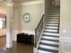 Spacious foyer with staircase, dark wood furniture, and wall clock, creating a welcoming entry at 160 Elysian Dr, Fayetteville, GA 30214