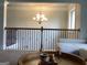 The living room features a modern chandelier and an iron railing on the second floor at 160 Elysian Dr, Fayetteville, GA 30214