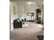 Cozy living room featuring a comfortable gray couch, treadmill, fireplace, and flat screen television at 160 Elysian Dr, Fayetteville, GA 30214