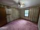 Bedroom featuring wood-paneled walls, carpeted flooring, and natural light from a window at 125 Rosenwald Cir, Stockbridge, GA 30281