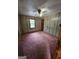Bedroom featuring a ceiling fan, paneled walls, carpeted flooring, and a window overlooking trees at 125 Rosenwald Cir, Stockbridge, GA 30281