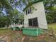 View of the exterior with sliding glass door, green siding, and a backyard surrounded by mature trees at 125 Rosenwald Cir, Stockbridge, GA 30281