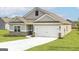 View of the charming single-Gathering home with two-car garage and well-manicured lawn at 256 Oliver Dr, Locust Grove, GA 30248
