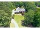 Aerial view of a brick home featuring mature landscaping, a circular driveway, and lush surroundings at 660 Milton Dr, Mcdonough, GA 30252