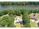 Aerial view of a brick home surrounded by mature trees, with river access and a well-manicured lawn at 660 Milton Dr, Mcdonough, GA 30252